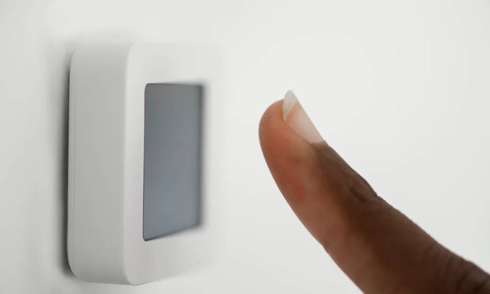 Persona activando un sistema de alarma mediante un panel táctil inteligente