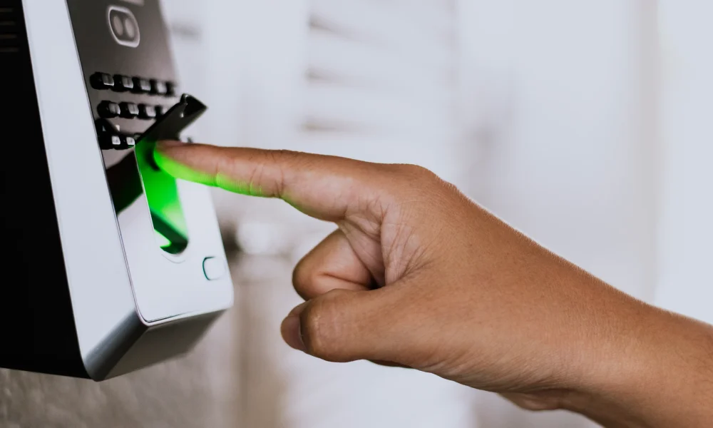Persona utilizando un lector de huella digital para acceder mediante sistema biométrico